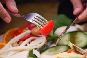 Enjoying a fresh salad with colorful vegetables and vibrant garnishes photo