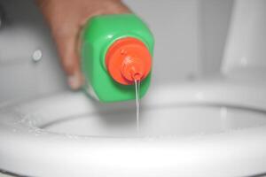 Cleaning solution being poured into a toilet for sanitation photo