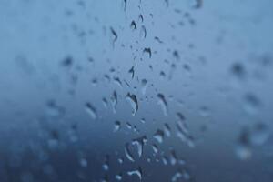 Raindrops on a window create a serene atmosphere during a rainy day photo