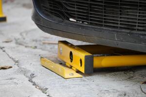 Car immobilizer device used on vehicle in urban parking area photo