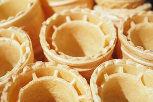 Waffle cones stacked in a bakery ready for filling with ice cream photo