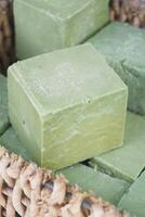 Handmade green soap blocks stacked for sale at a market photo