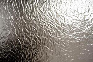 Crinkled Silver Foil Texture Background - Abstract Crumpled Metallic Paper Surface with Shiny Reflections photo