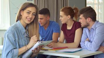 Caucasian girl writes in her notebook while collaborating with colleagues video