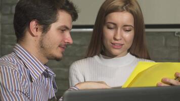 Dynamic duo collaborating on documents in a modern office video