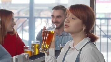 Charming woman smiling to the camera while enjoying a refreshing beer video
