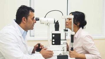 A skilled doctor examines the patient's eyes with a specialized device video
