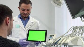 Dentist explains treatment options on a tablet to his male patient video