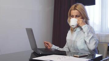 Smiling woman enjoys coffee while working on a call video