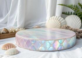 A round iridescent platform with a mosaic pattern on the side, surrounded by seashells and pearls, on a white fabric background photo