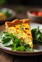 A slice of quiche with bacon bits and a sprig of parsley on a plate surrounded by arugula, in a rustic kitchen photo