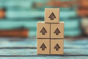 Stacked cardboard boxes with arrows indicating direction on a rustic wooden surface photo