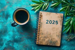 2025 on notebook, coffee cup on table. photo