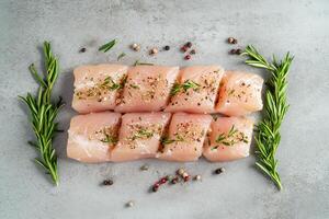 Chicken fillet with herbs and spices on gray table flat lay. photo