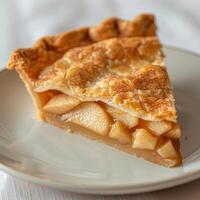 A delicious looking apple pie slice on a white plate, ready to be enjoyed. photo