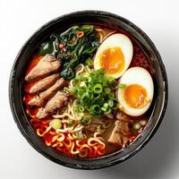 A bowl of Ramen soup topped with two eggs cooked sunny side up, sliced meat, photo