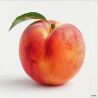 A peach in a white background. It has a red color and a green leaf attached to it. photo