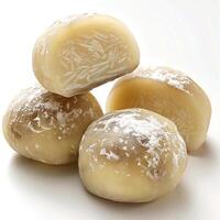 A pile of four round chocolate candies with almonds, resting on a white surface. photo