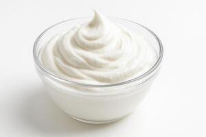 Clear glass bowl filled with creamy, smooth white Greek yogurt on plain white background photo