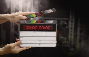 Digital film slate for filmmaker in set. Hand hitting timecode clapperboard or movie slate for Production. Digi number clapper board or film slates action on set. Tools in modern cinema industry. photo