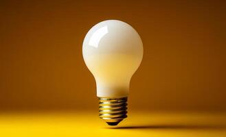 Light bulb on yellow bg. A light bulb floats in mid-air, casting soft reflections on its smooth surface against a vibrant yellow background. photo