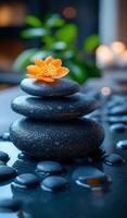 Stones and flowers in harmony. Three smooth stones stacked with an orange flower on top, creating a serene atmosphere in a tranquil setting. photo