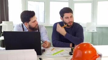 Two architects passionately discuss plans at the table video