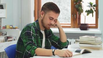 Exhausted student dozes off while studying in a bright classroom video