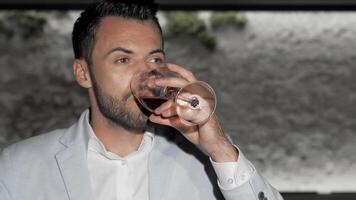 Charming bearded man savoring a glass of red wine at a stylish bar video