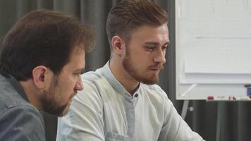 Focused collaboration between two male business colleagues in a modern office video