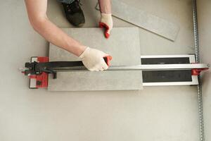 The master machine cuts the tile into two parts. A machine for cutting large ceramic tiles into smaller tiles with precise dimensions. photo