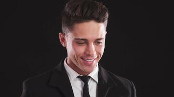Charming man laughs before shifting to a serious gaze at the camera video