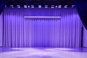 A podium stage with trendy purple lighting. Fabric wavy background with space for copying. An element for your design photo