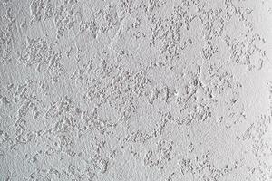 Background with the texture of a white plastered wall. Uneven background with the texture of decorative plaster painted in white concrete wall. Rough wall with space for copying photo