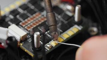 Technician soldering components onto circuit board of disassembled fpv drone video