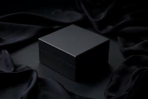 Mysterious black box resting on draped satin cloth creating dramatic contrast photo