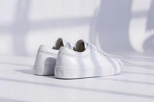 Crisp white sneakers on a minimalist backdrop with subtle shadows and clean lines photo