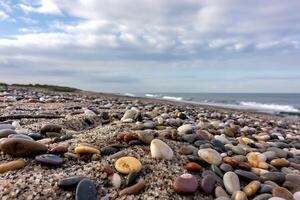 Pebbled coastal scene A textured beachscape under a cloudy expanse of sky photo