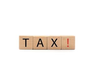 Wooden blocks with TAX text isolated on white background. wooden cubes TAX with copy space and clipping path. Tax avoidance. Costs and expenses of the business. photo