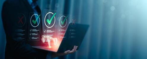 Business Professional Evaluating Checklists on Laptop with Futuristic Virtual Interface, Highlighting Quality Assurance, Decision-Making, Task Management, Project Planning, Successful Goal Completion photo