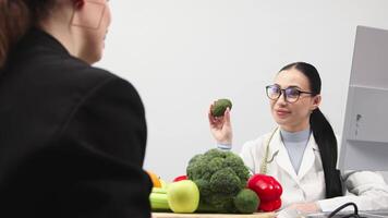 Nutritionist doctor consulting overweight patient, providing advice on healthy eating plan and creating a diet program. They discussing the importance of including vegetables in the diet video