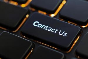 Glowing Contact Us Key on Modern Keyboard. Instant Communication Concept for Digital Media Design photo