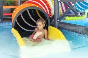 Child on colorful water slide exit photo