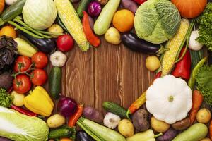 Top view of various vegetables on a wooden table with copy space. photo