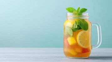 A glass jar with a pitcher of lemonade and mint leaves photo