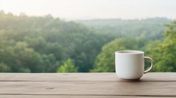 A cup of coffee sits on a wooden table in front of a forest photo