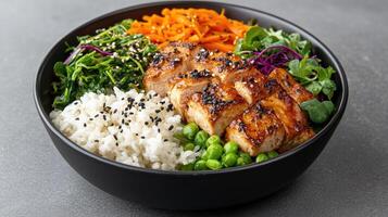 A bowl of rice, vegetables and meat with sesame seeds photo