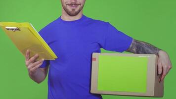 Cheerful deliveryman holding a clipboard and a cardboard box video