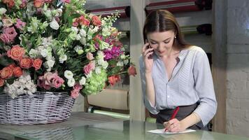 Charming female florist takes an order for a stunning bouquet at her flower shop video