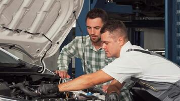 Mechanic expertly repairs automobile while engaging with attentive customer video